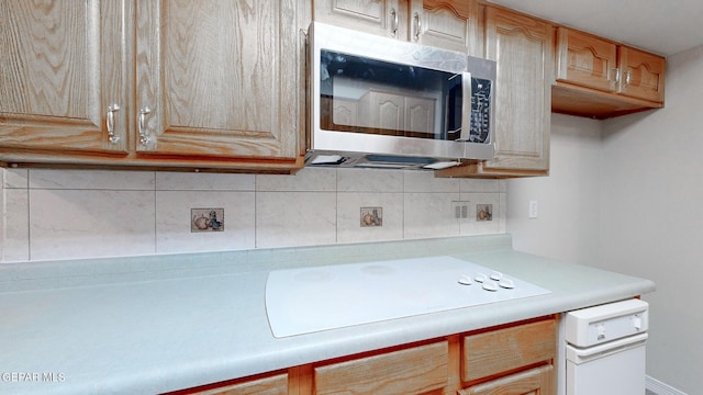 kitchen with tasteful backsplash, light countertops, stainless steel microwave, and light brown cabinets