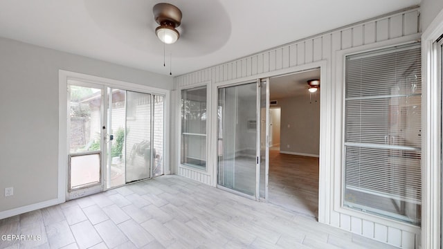 unfurnished sunroom featuring a ceiling fan