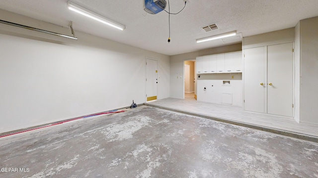 garage featuring a garage door opener and visible vents