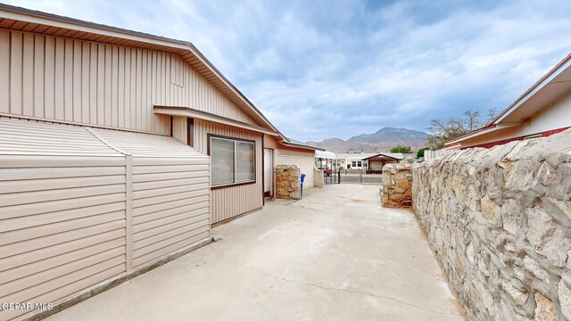 view of side of property with a mountain view and a patio