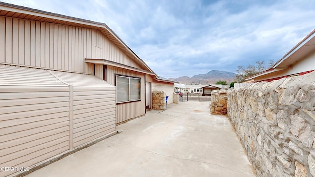 view of patio with fence and a mountain view