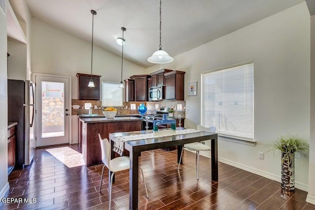 dining room with high vaulted ceiling and dark hardwood / wood-style flooring