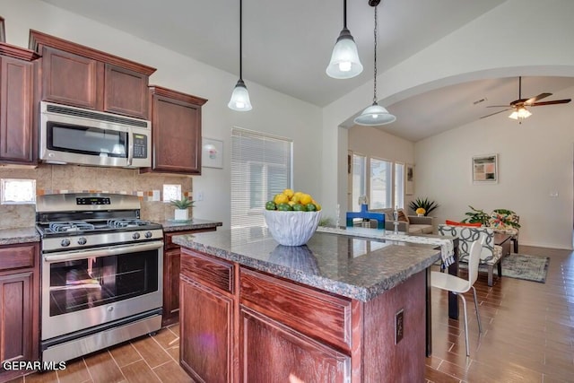 kitchen featuring wood-type flooring, appliances with stainless steel finishes, lofted ceiling, and pendant lighting