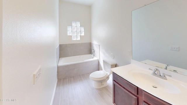 bathroom with vanity, tiled bath, hardwood / wood-style flooring, and toilet