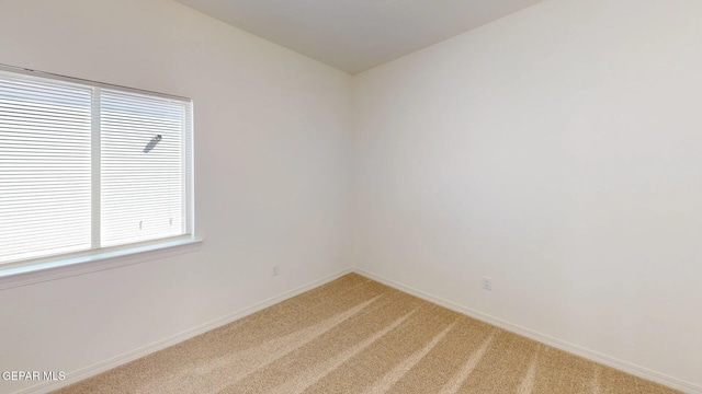 carpeted spare room featuring a wealth of natural light