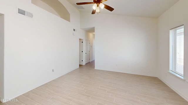 unfurnished room with ceiling fan, vaulted ceiling, and light wood-type flooring