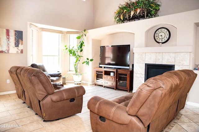 living area featuring a tile fireplace and baseboards