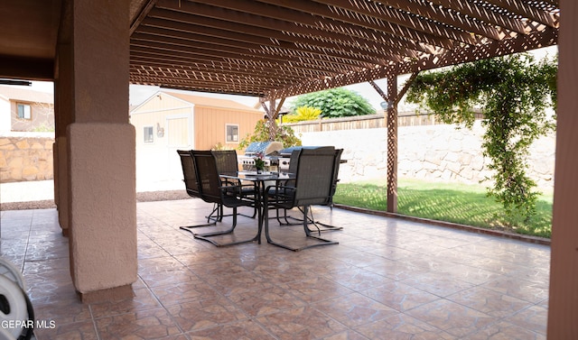 view of patio / terrace featuring fence, a shed, outdoor dining area, an outbuilding, and a pergola