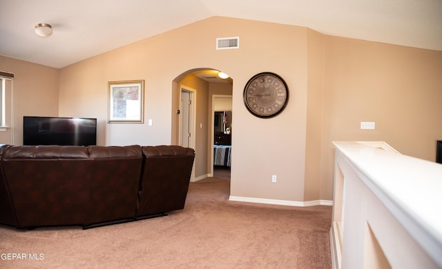 living area featuring visible vents, light carpet, arched walkways, baseboards, and vaulted ceiling