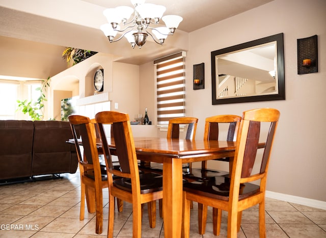 dining area featuring tile patterned flooring, baseboards, and a chandelier