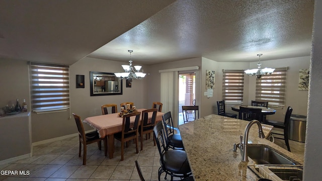 dining space featuring a textured ceiling, light tile patterned floors, baseboards, and a chandelier