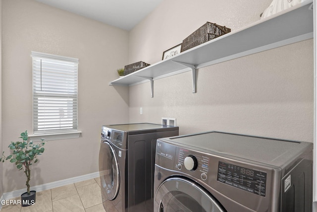 washroom with light tile patterned floors and washing machine and clothes dryer