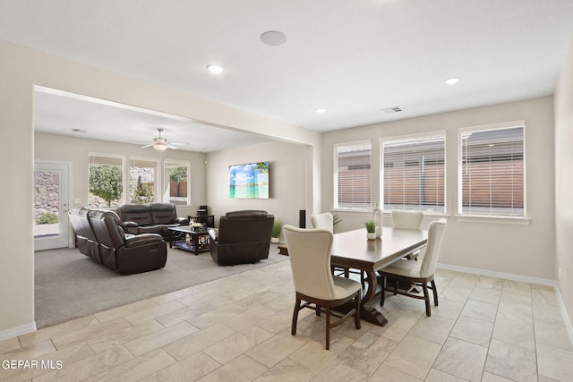 carpeted dining room with ceiling fan