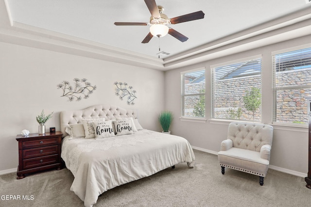 bedroom with a tray ceiling, ceiling fan, and carpet