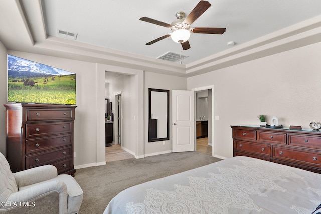 carpeted bedroom featuring ceiling fan and a tray ceiling