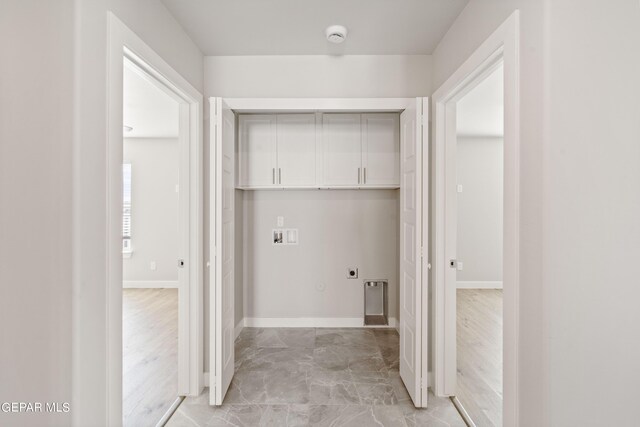 clothes washing area with cabinets, hookup for a washing machine, light hardwood / wood-style floors, and electric dryer hookup