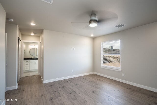empty room with ceiling fan and light hardwood / wood-style floors