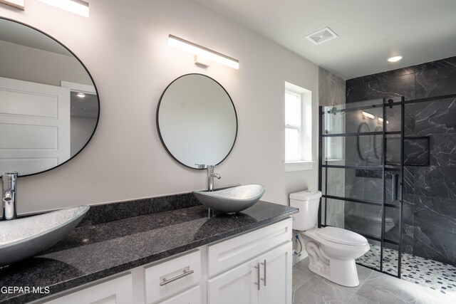 bathroom featuring vanity, toilet, and a shower with door