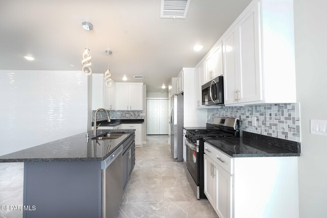kitchen featuring decorative backsplash, sink, white cabinets, and appliances with stainless steel finishes