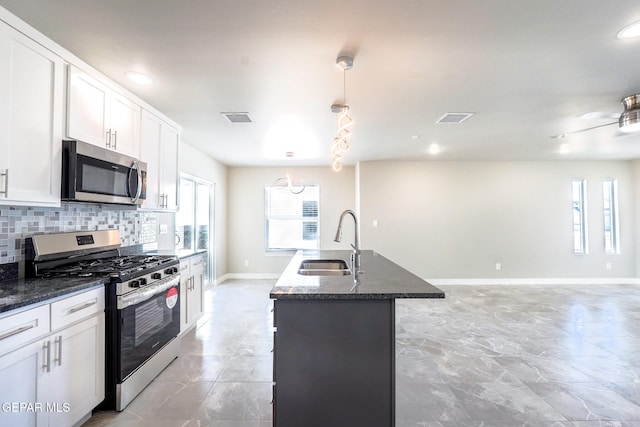 kitchen with white cabinets, pendant lighting, sink, and appliances with stainless steel finishes