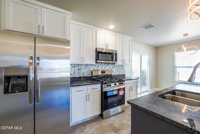 kitchen featuring white cabinets, appliances with stainless steel finishes, backsplash, and sink