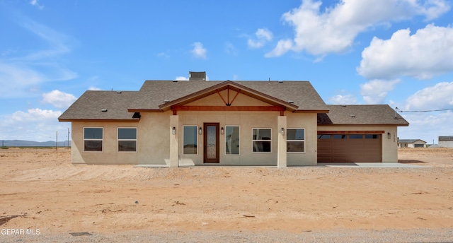 1385 Syrian Desert Dr, Chaparral, NM 88081 - rear view of house featuring stucco siding, an attached garage, roof with shingles, and driveway