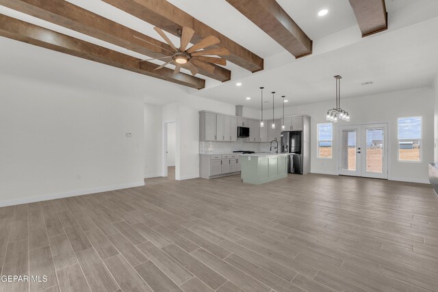 1385 Syrian Desert Dr, Chaparral, NM 88081 - unfurnished living room with beamed ceiling, ceiling fan, french doors, recessed lighting, and a chandelier