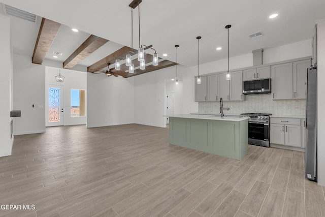1385 Syrian Desert Dr, Chaparral, NM 88081 - kitchen with stainless steel appliances, light countertops, beamed ceiling, tasteful backsplash, and light wood-type flooring