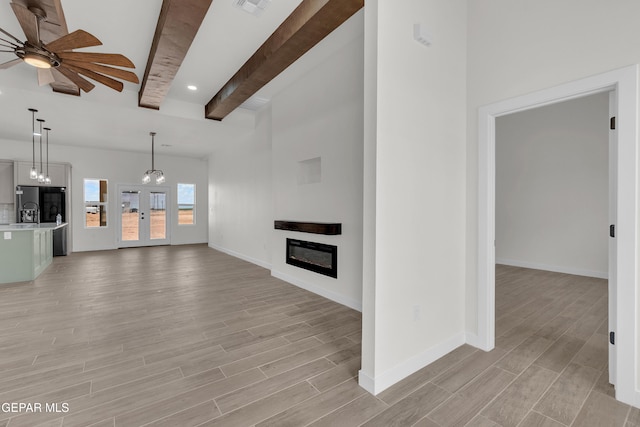 1385 Syrian Desert Dr, Chaparral, NM 88081 - unfurnished living room featuring beam ceiling, a ceiling fan, light wood-style flooring, a glass covered fireplace, and recessed lighting