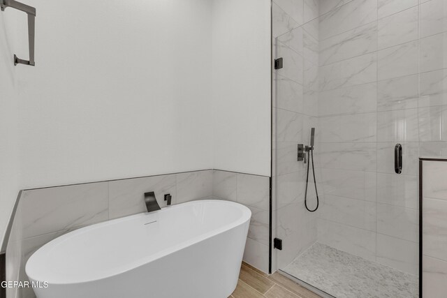 1385 Syrian Desert Dr, Chaparral, NM 88081 - bathroom with a stall shower, a freestanding tub, and wood finished floors