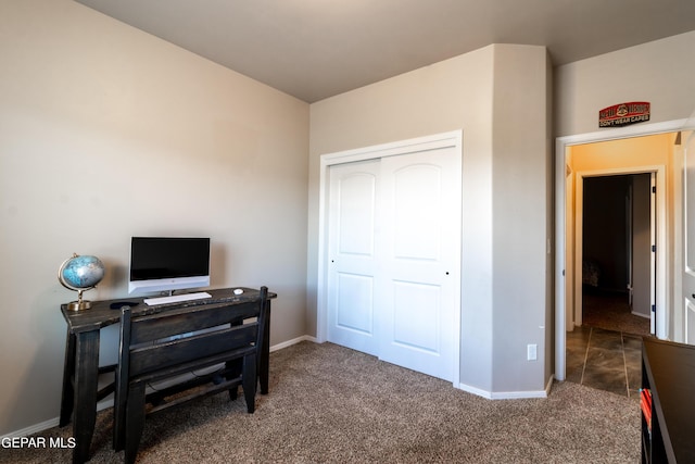 carpeted bedroom with a closet and baseboards