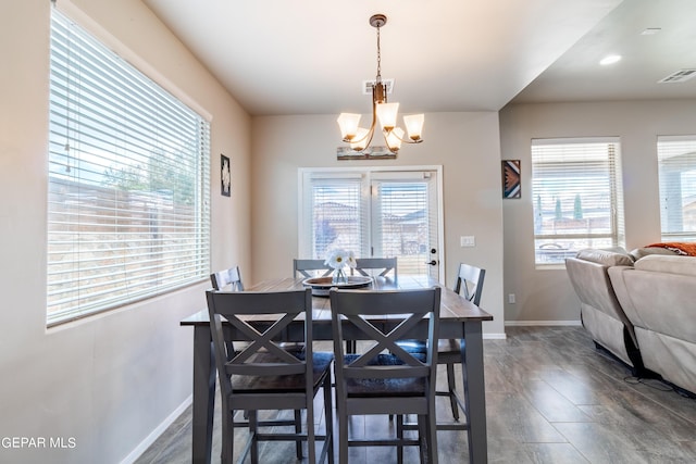 dining room featuring baseboards, visible vents, and a chandelier