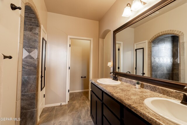 bathroom featuring double vanity, visible vents, baseboards, and a sink