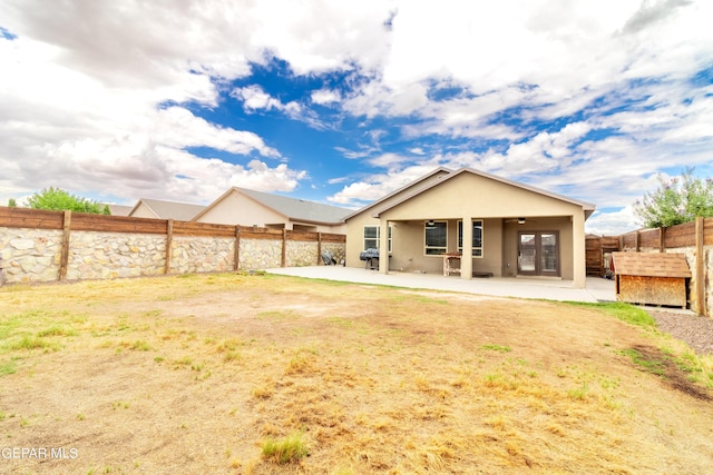 rear view of house with a patio, a fenced backyard, a ceiling fan, and stucco siding