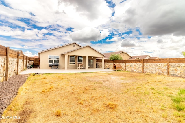 rear view of property with a patio area, a fenced backyard, and stucco siding