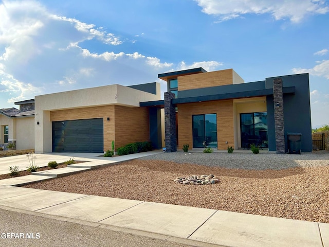 contemporary home with stucco siding, driveway, and an attached garage