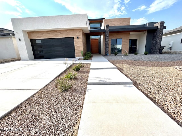 contemporary home with stucco siding, driveway, and a garage