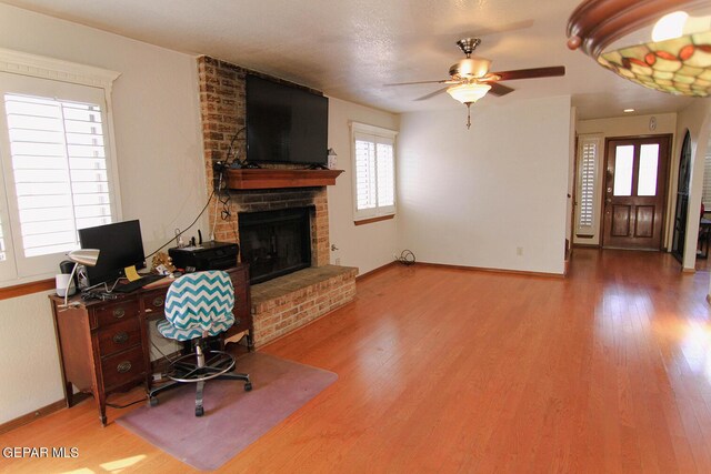 office space with a fireplace, hardwood / wood-style flooring, and ceiling fan