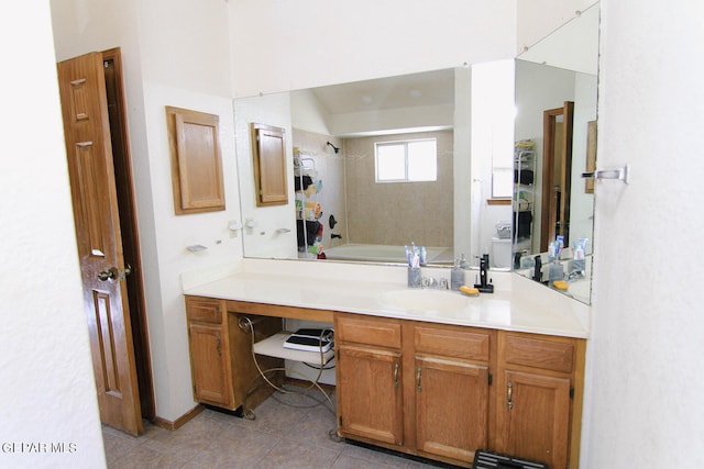 bathroom with tile patterned flooring, tiled shower / bath combo, and vanity