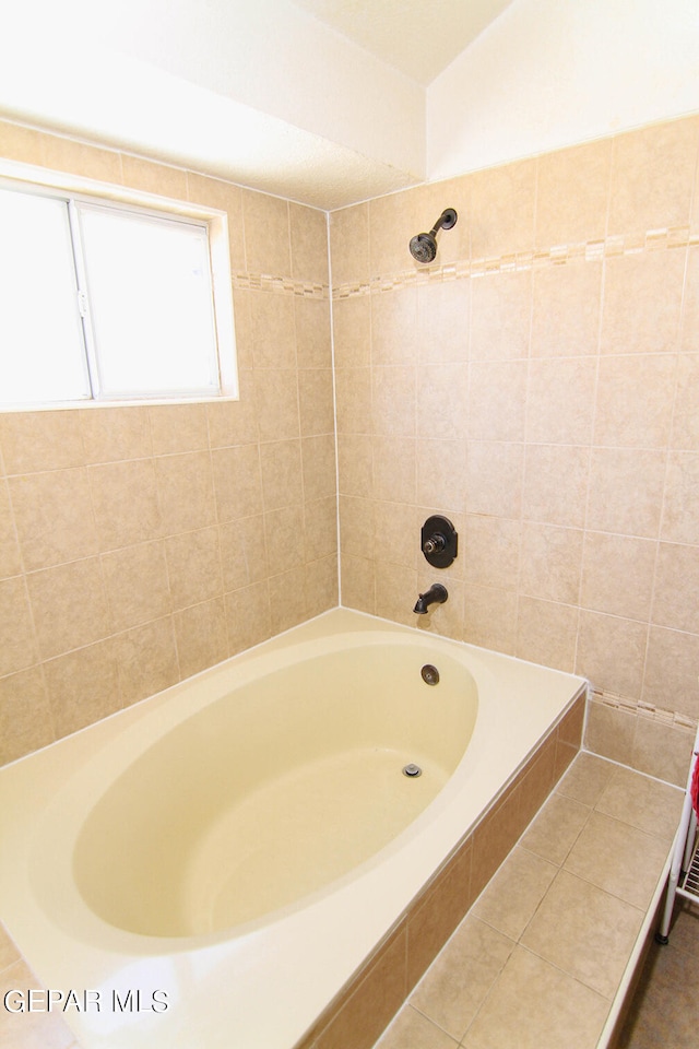 bathroom featuring tiled shower / bath and tile patterned flooring