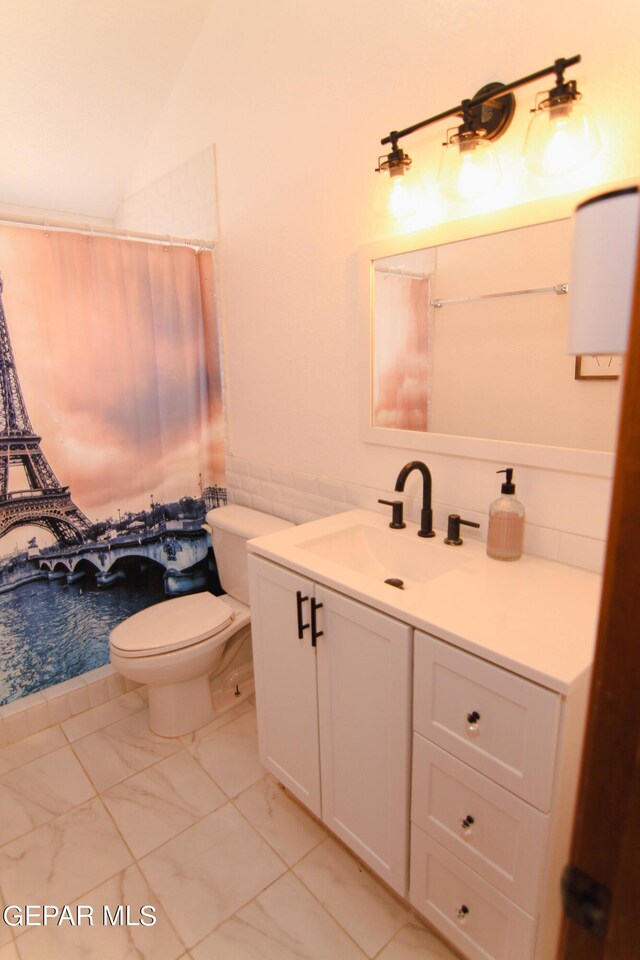 bathroom with vanity, toilet, a shower with curtain, and lofted ceiling