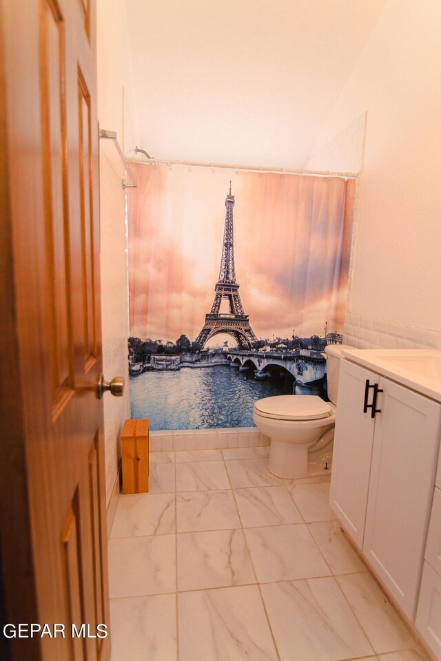 bathroom with vanity, toilet, vaulted ceiling, and walk in shower