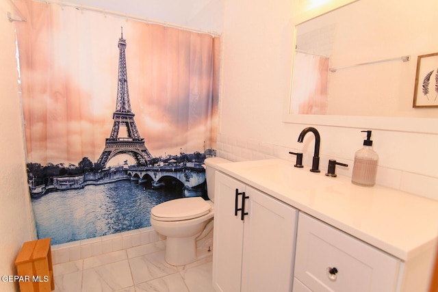 bathroom featuring marble finish floor, vanity, and toilet