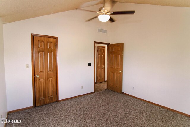 unfurnished bedroom featuring ceiling fan, carpet, a textured ceiling, and vaulted ceiling