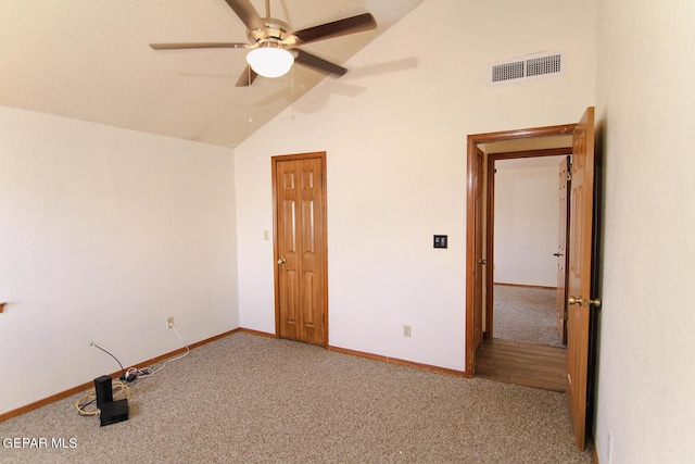 carpeted empty room with high vaulted ceiling, baseboards, visible vents, and ceiling fan