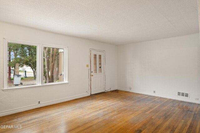 unfurnished room featuring a textured ceiling and hardwood / wood-style flooring