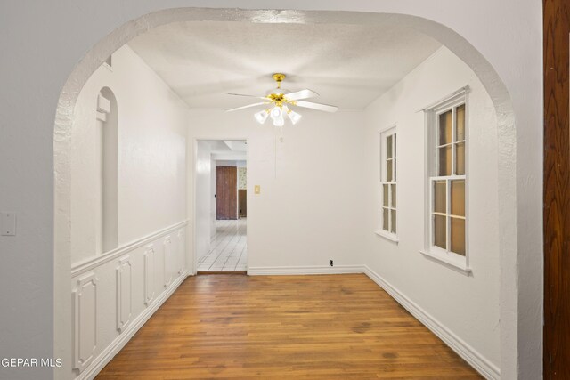 unfurnished room featuring a textured ceiling, hardwood / wood-style flooring, and ceiling fan