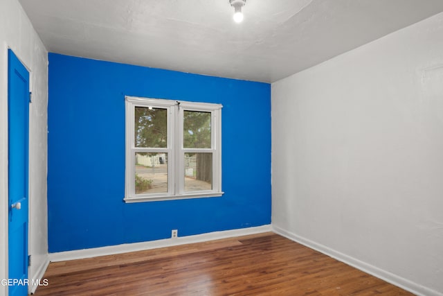 spare room with a textured ceiling and hardwood / wood-style flooring