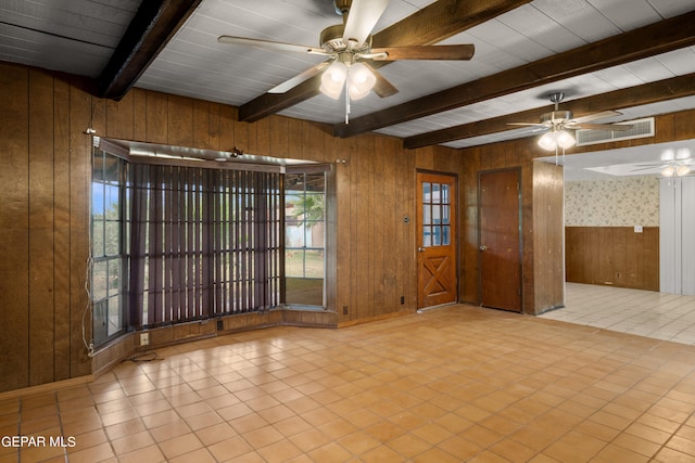 tiled empty room with ceiling fan, wood walls, beamed ceiling, and wooden ceiling