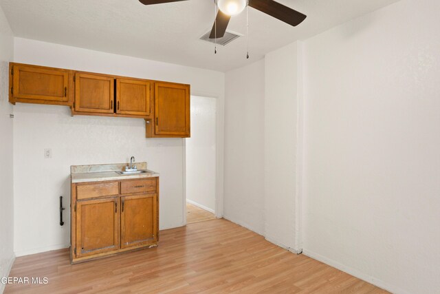 kitchen featuring light hardwood / wood-style flooring, sink, and ceiling fan